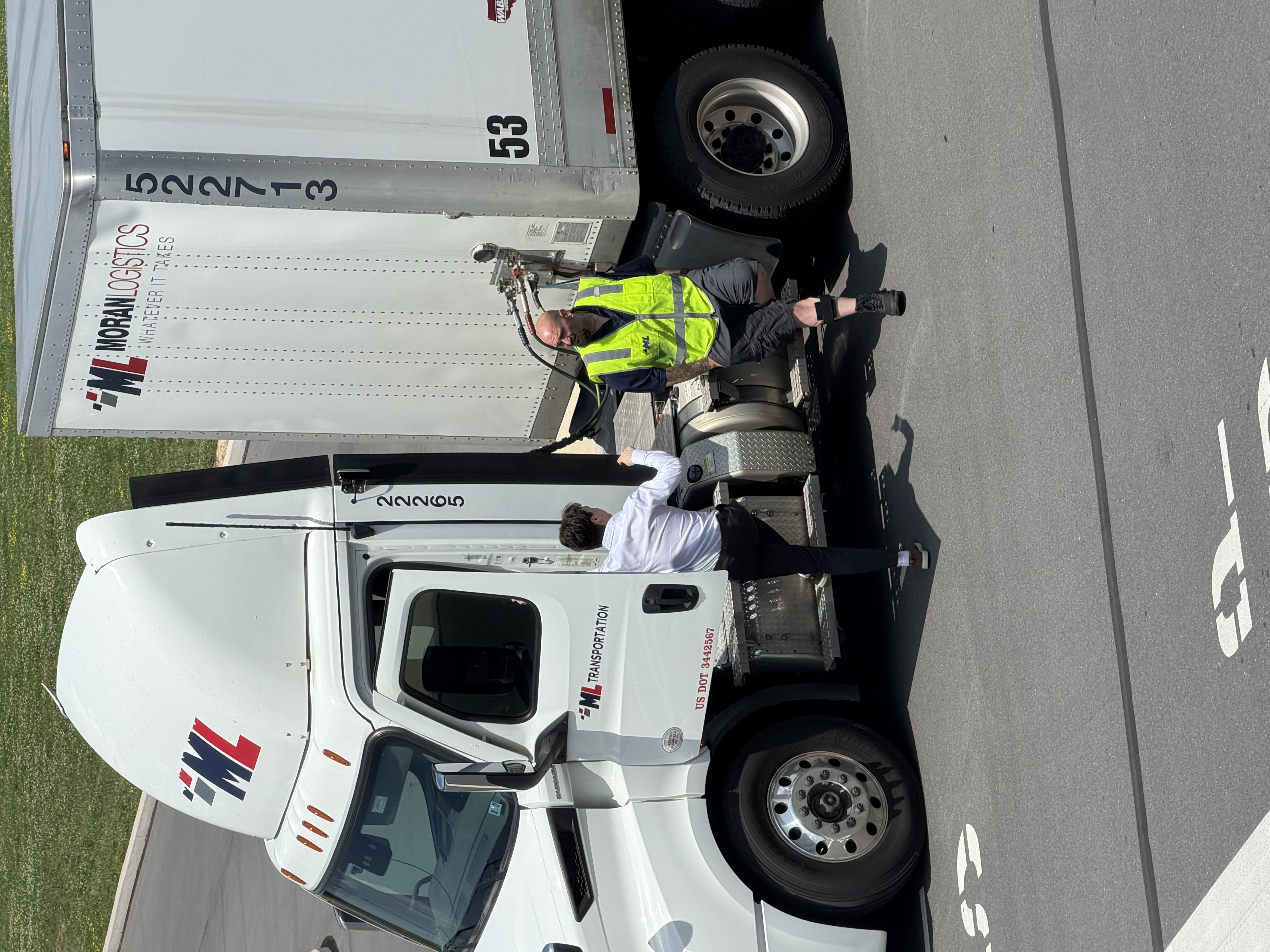 A Movo team member reviewing an operational workflow with a Moran Logistics operator beside a truck