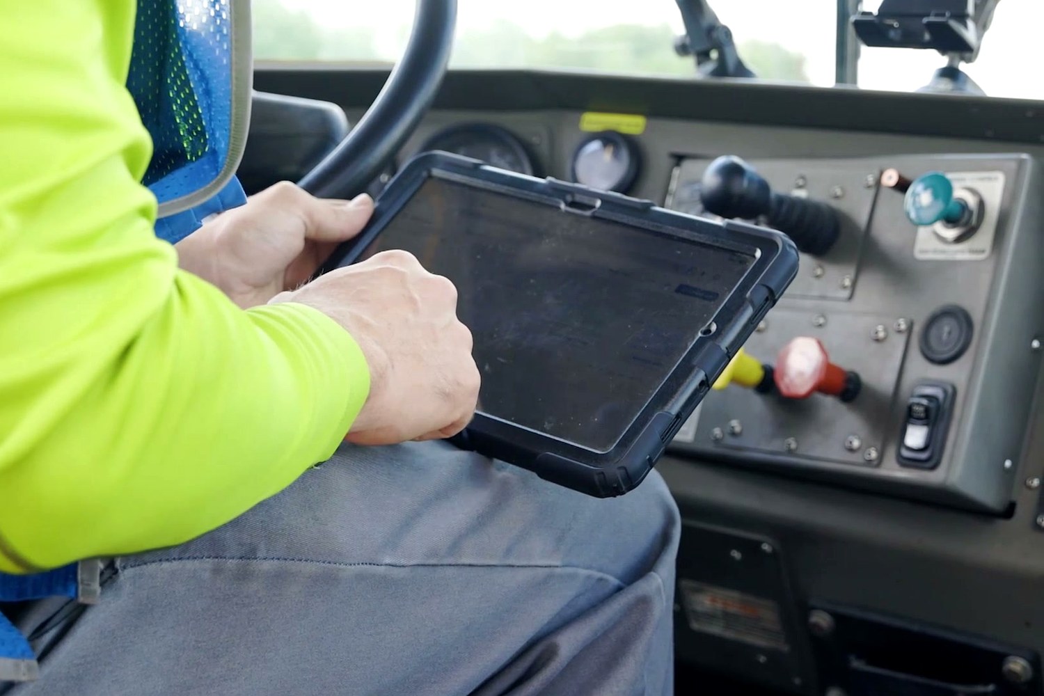 A yard jockey using a rugged tablet in the cab of a jockey truck